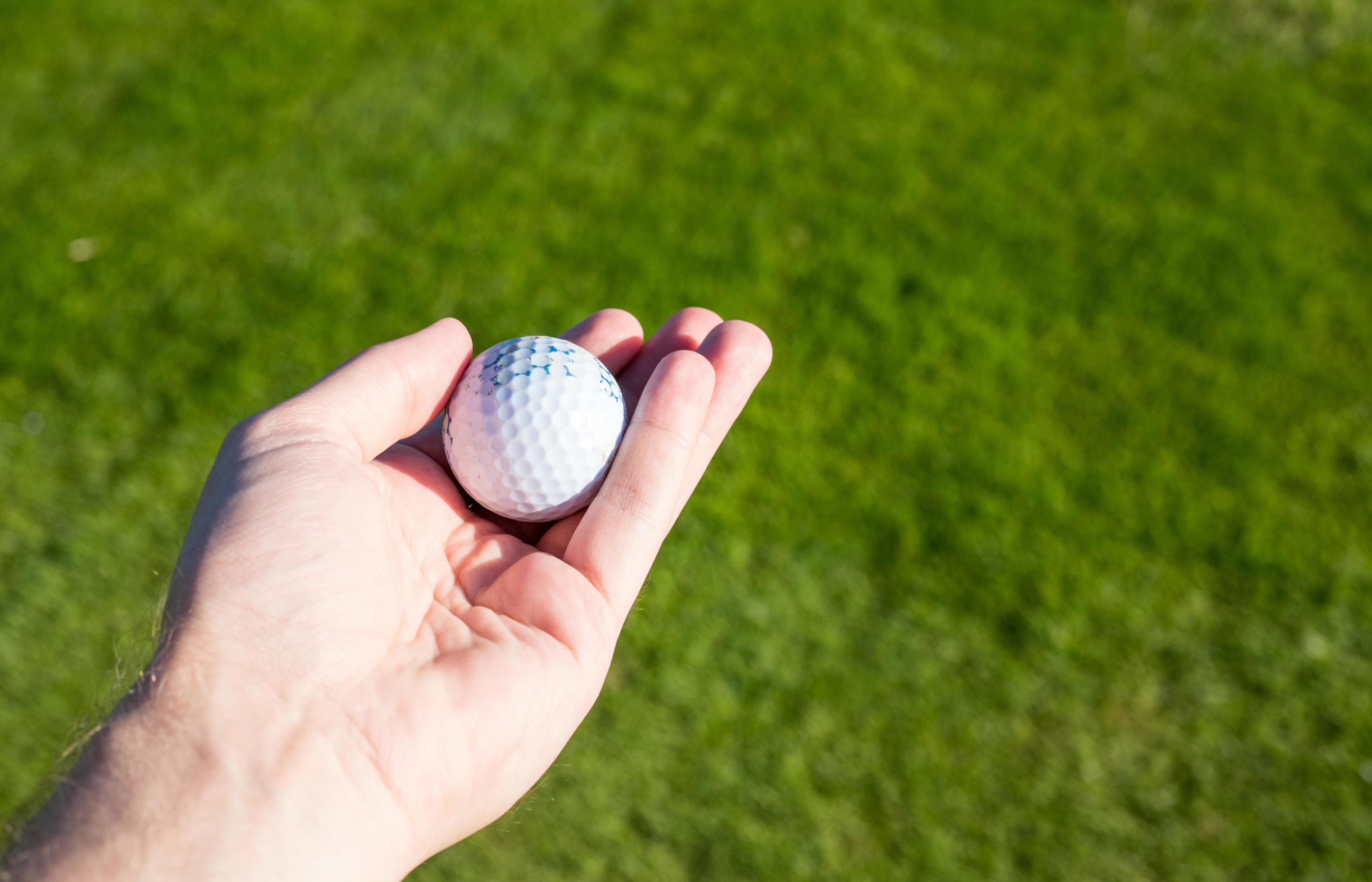 golf-ball-held-in-hand-on-the-golf-course-golf-concept-free-photo.jpg