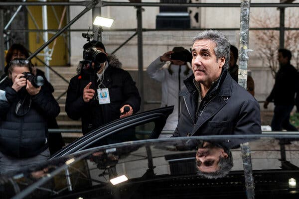 Michael Cohen getting into a car outside a courthouse as news photographers take his picture.