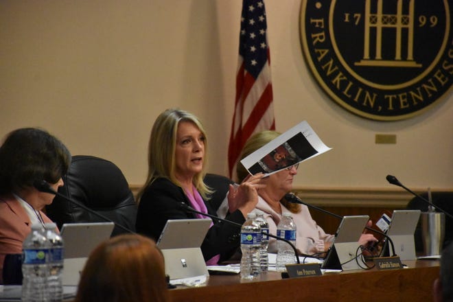 Franklin Alderman Gabrielle Hanson holds up pictures of performers at the Franklin Board of Alderman meeting April 11.