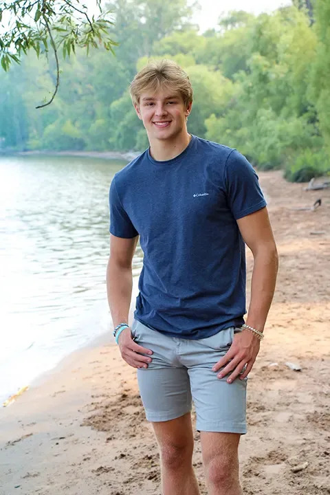 Jordan DeMay posing by a lake