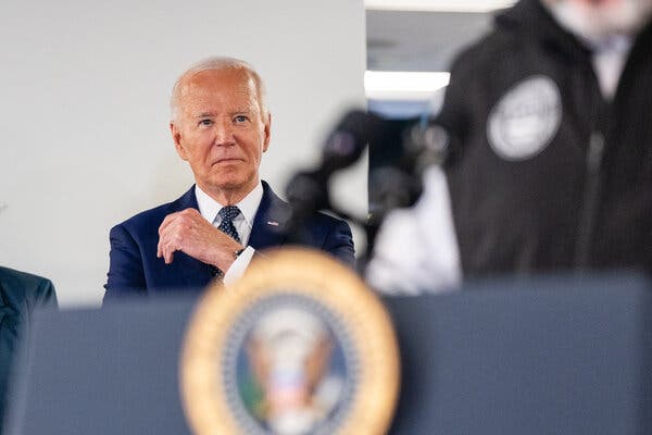 President Biden standing near a lectern with the presidential seal.