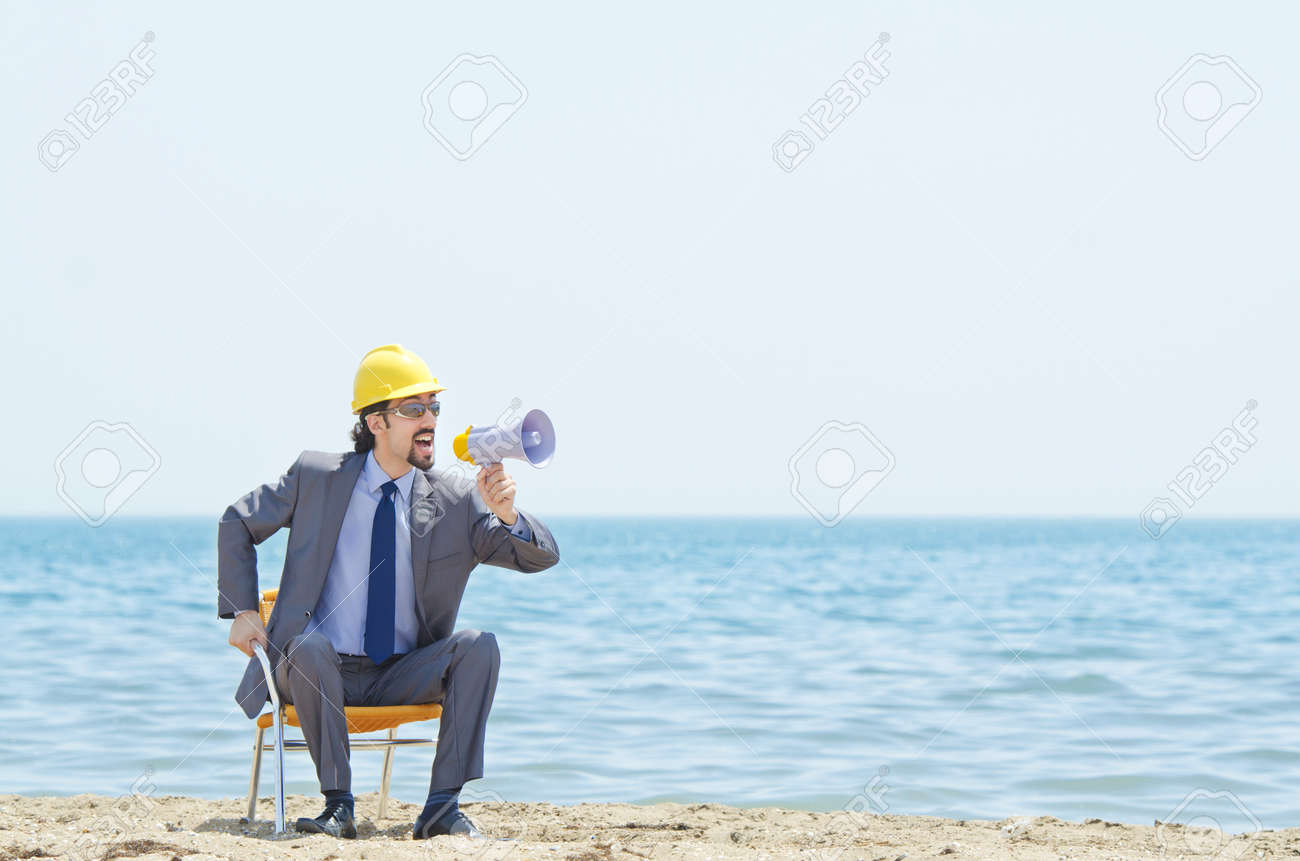 14385248-man-with-hard-hat-and-loudspeaker-on-beach.jpg