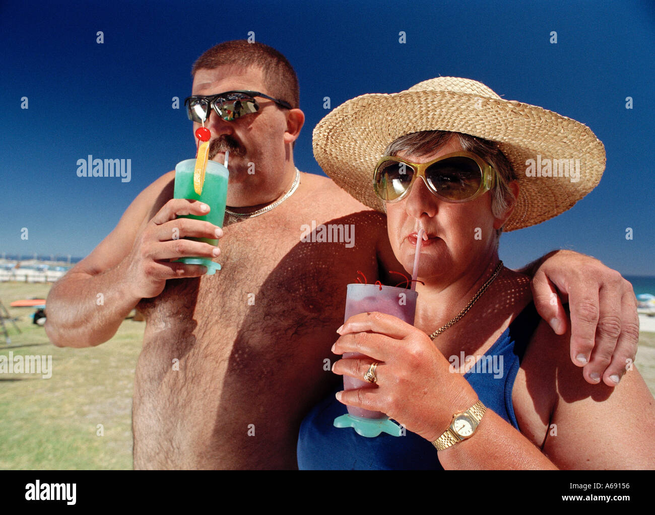fat-couple-on-beach-drinking-cocktails-A69156.jpg