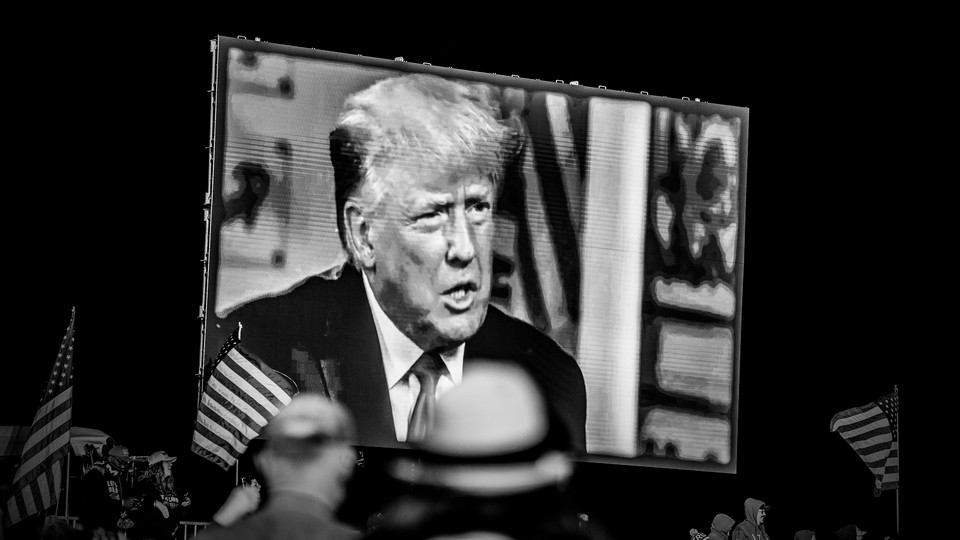 A black-and-white image of Donald Trump onscreen