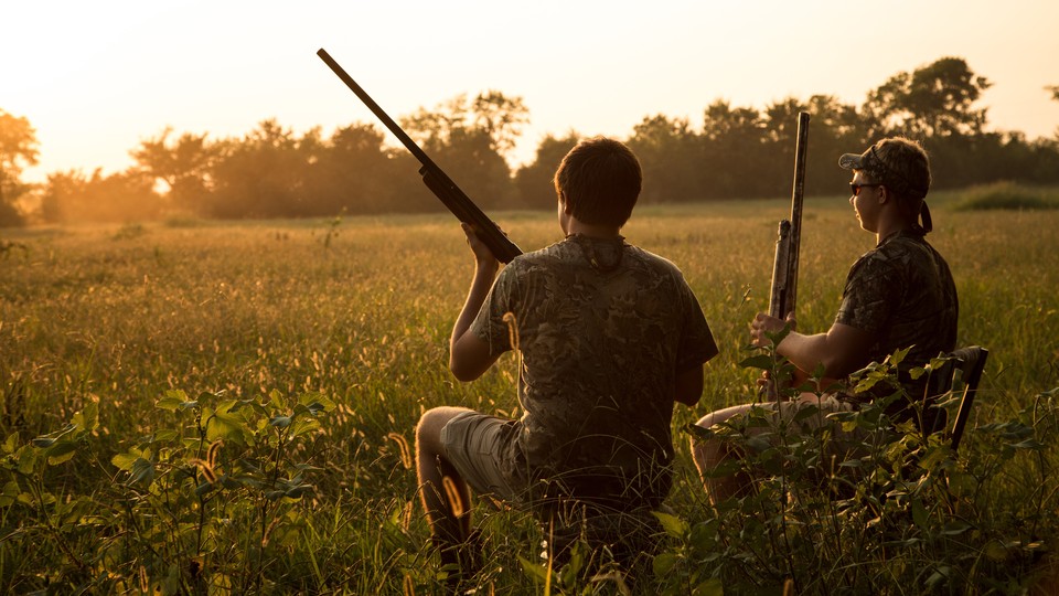 A photograph of two people hunting with rifles