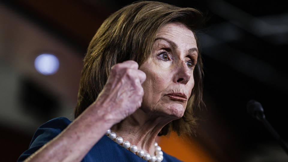 A photo of Nancy Pelosi holding her hand in a fist.