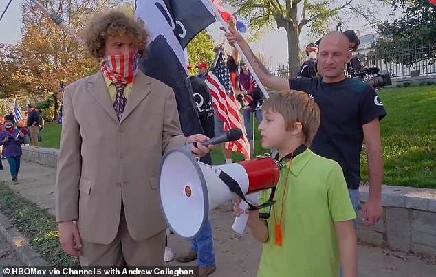 Jaden (lower right) was seen standing next to his father Brandon (right) at a QAnon rally while filmmaker Andrew Callaghan (left) captured the moment. The documentary follows Trump supporters leading up the January 6 riot