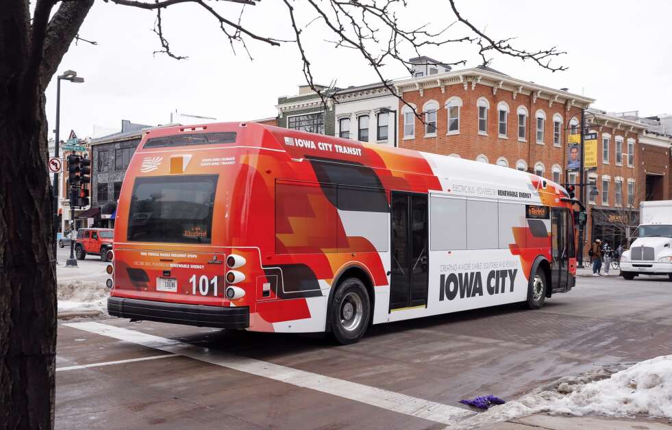 One of the electric buses in the Iowa City Transit fleet pulls away from its stop outside Old Capitol Town Center along the free downtown shuttle route in Iowa City, Iowa, on Thursday, January 27, 2022. (Jim Slosiarek/The Gazette)