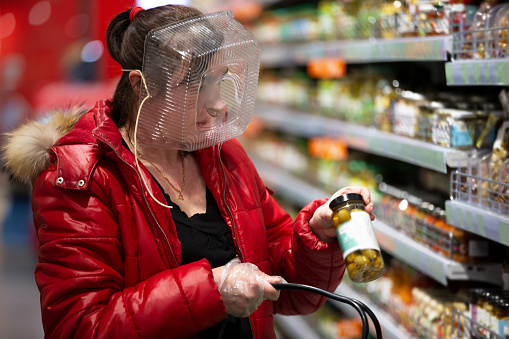 coronovirus-protection-woman-in-a-store-with-a-plastic-box-on-her-face-a-funny-way-to-protect.jpg