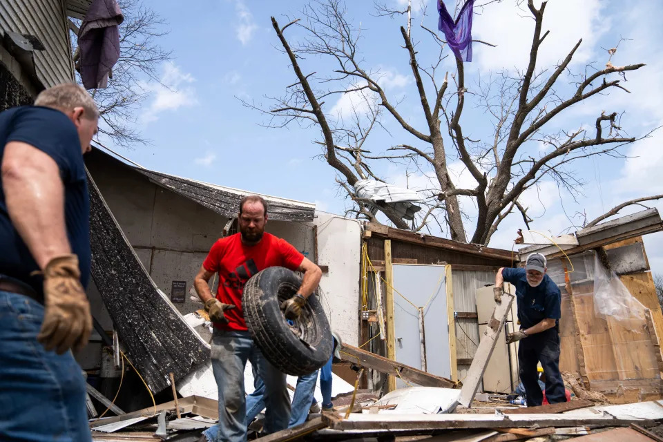 Residents work to clear the debris left by a strong tornado Saturday, April 27, 2024, in Tingley, IA.