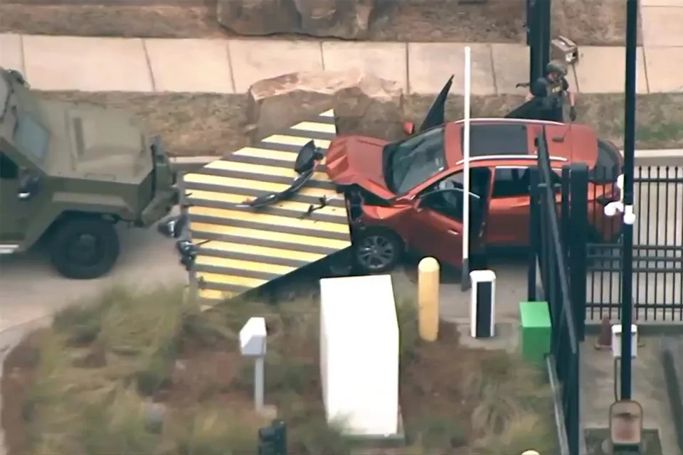 In an image taken from aerial video shows a red vehicle stopped by a barrier at the front gate of the Federal Bureau of Investigation Atlanta division, Monday, April 1, 2024, in Chamblee, Ga. The FBI says a driver rammed a vehicle into the front gate of its Atlanta office, but his motives were not immediately known. (WSB via AP)