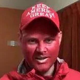 Daniel Donnelly Jr. wears a red “Keep America Great” hat and red face paint.