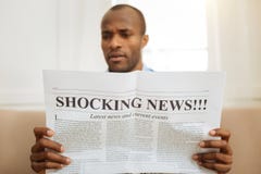 bewildered-man-reading-shocking-news-being-astonished-serious-astonished-afro-american-man-holding-newspaper-reading-106380599.jpg