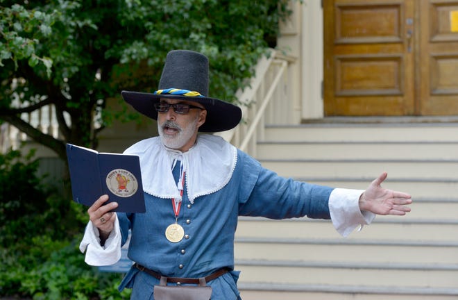 Provincetown Town Crier Daniel Gomez Llata gives an update Thursday in front of Provincetown Town Hall about the sewer emergency. He included a list of restaurants that were still open.