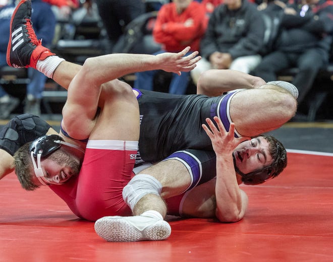 Northwestern's Max Mayfield (purple singlet) rallied late in the 165-pound bout to defeat Rutgers' Robert Kanniard 9-4. Northwestern won the match 28-6.