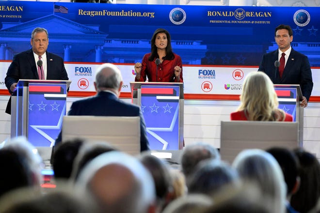 Former South Carolina Gov.ÊNikki Haley (center) speaks while former New Jersey Gov.ÊChris Christie (left) and Florida Gov.ÊRon DeSantis listen during the FOX Business Republican presidential primary debate at the Ronald Reagan Presidential Library and Museum.