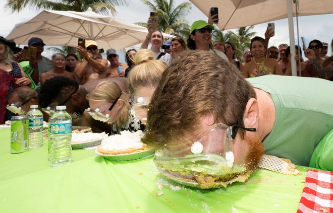 Joshua Mogle, right, of Altoona, Iowa, buries his face in a Key lime pie as he eats his way to victory at the World Famous Key Lime Pie Eating Championship Tuesday, July 4, 2023, in Key West, Florida.